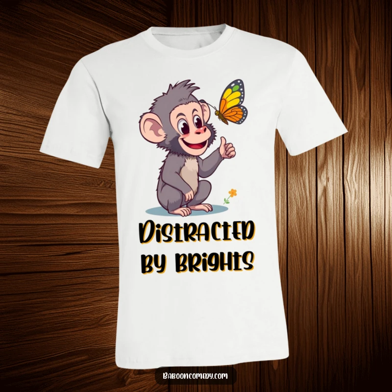 Funny t-shirt featuring a curious baboon excitedly pointing at a vibrant, colorful butterfly, embodying a sense of awe and natural fascination.